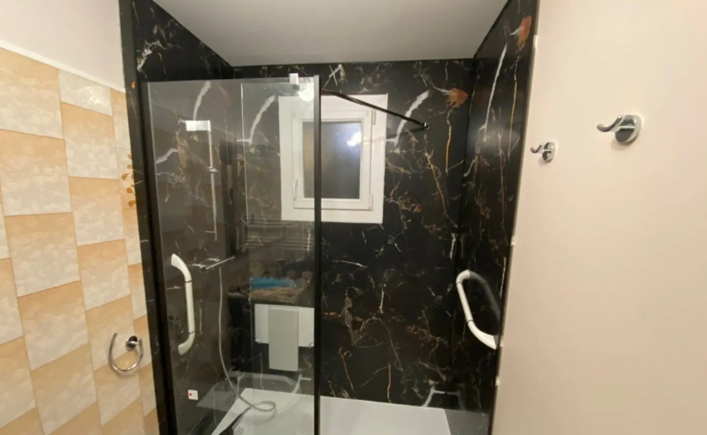 Douche effet marbre noir réalisée avec Aqua Habita